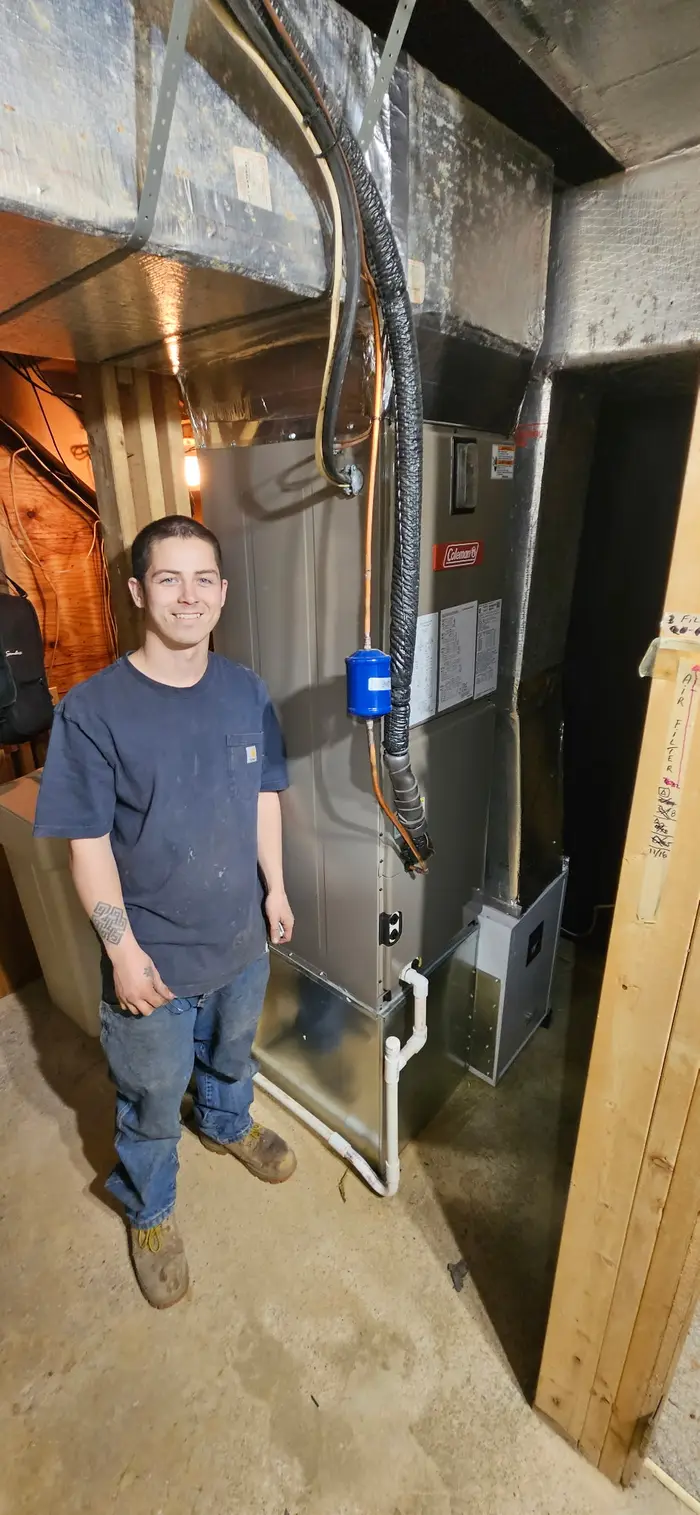 AirSorce-1 technician standing next to completed Coleman furnace installation in Terre Haute Indiana